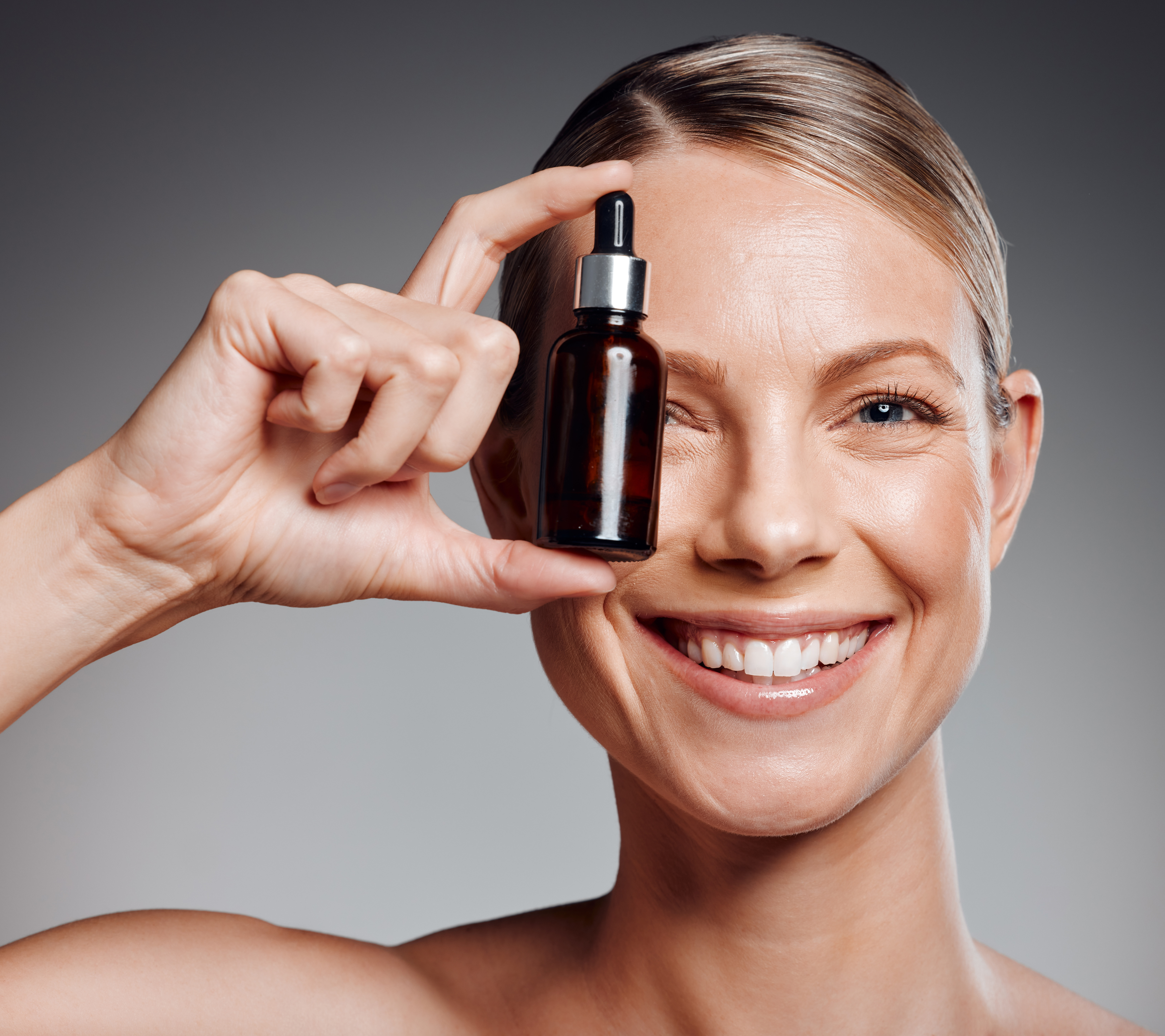 Pipette dispensing a high-strength Neuro Glow active serum into the palm of a hand
